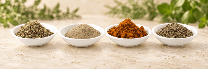 Cuatro recipientes con especias y hierbas aromáticas